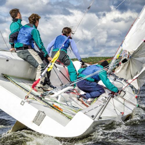 Group of people on a sailboat in a team-building exercise